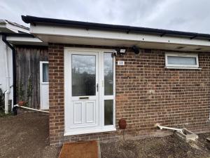a brick house with a white door at Amirs house in Hackington