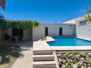 a swimming pool in front of a building with a table at La Oliva in San Martín