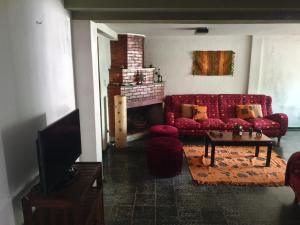 a living room with a red couch and a fireplace at La Oliva in San Martín