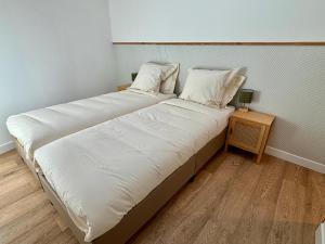 a bedroom with two beds and a night stand at L'Écrin Rustique in Couzeix
