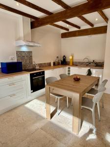 a kitchen with a wooden table and chairs at L'Écrin Rustique in Couzeix