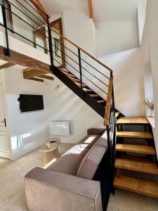 a living room with a staircase and a couch at L'Écrin Rustique in Couzeix