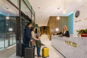 a group of people with luggage standing in a lobby at Premium New Gudauri Apartments with Balcony & Gondola Views in Gudauri