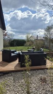a patio with black couches on a wooden deck at Ferienhaus Alpenblick in Steinen