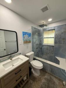 a bathroom with a toilet and a shower and a sink at 1008 Gardens in Vero Beach +15 photos