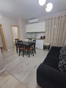 a living room with a table and chairs and a kitchen at holiday house in Durrës +12 photos