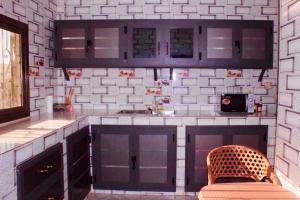 a kitchen with purple cabinets and a chair in it at MK Hebergement in Saint-Louis