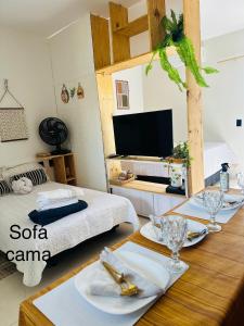 a room with a bed and a table with dishes on it at Flat Dourado a 5minutos do Parnaíba Shopping in Parnaíba