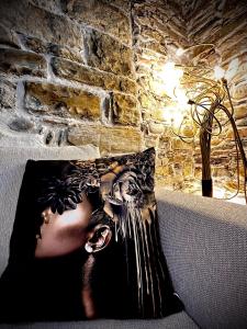 a magazine sitting on a couch next to a brick wall at Perla Loft in Seriate