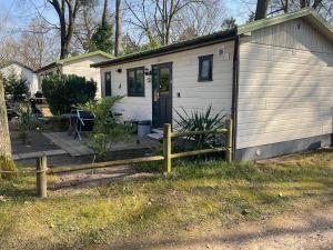 a small house with a wooden fence in front of it at Chalet C5 in Heel +3 photos