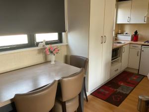 a kitchen with a table with chairs and a vase of flowers at Chalet C5 in Heel