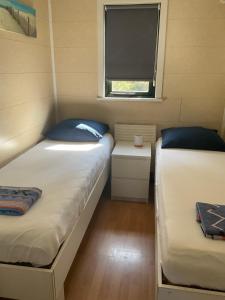 two beds in a small room with a window at Chalet C5 in Heel