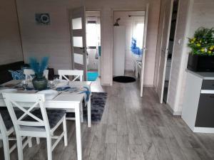a dining room with a white table and chairs at Domki Pod Świerkami in Jezierzany +7 photos