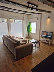 a living room with a couch and a tv at Old City Apartment Möckmühl in Möckmühl