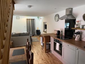a kitchen and a living room with a couch at Yew Trees Barn in Backwell