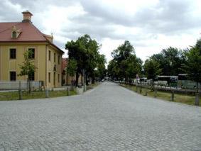 eine leere Straße mit einem Haus und einem Gebäude in der Unterkunft Hotel Landhaus Moritzburg in Moritzburg
