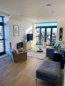 a living room with a couch and a chair at Top-end penthouse with sea views and free parking in Ramsgate