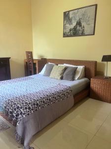 a bedroom with a bed and a picture on the wall at Airport home stay in Ekala +17 photos