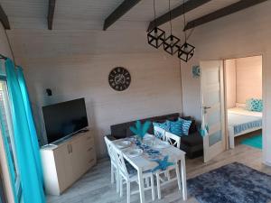 a living room with a table and a couch at Domki Pod Świerkami in Jezierzany