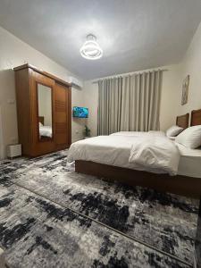 a bedroom with a large bed and a mirror at Terra Pyramids Hotel in Cairo