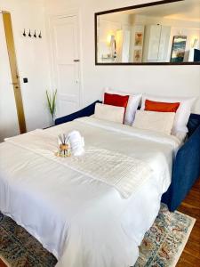 a bedroom with a large white bed with red pillows at Le petit Versailles in Versailles