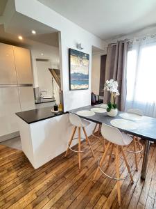 a kitchen and dining room with a table and chairs at Le petit Versailles in Versailles