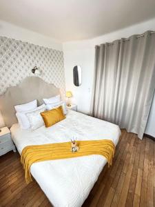 a bedroom with a large white bed with yellow accents at Le petit Versailles in Versailles +40 photos