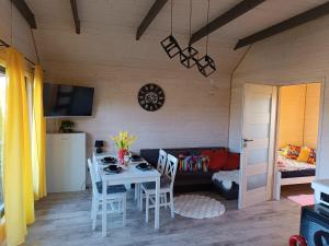 a living room with a table and chairs and a couch at Domki Pod Świerkami in Jezierzany
