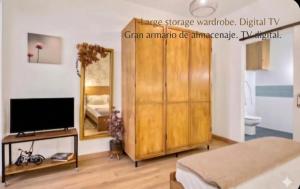 a bedroom with a large wooden wardrobe and a mirror at URBAN LOFT VALENCIA in Valencia