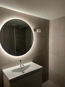 a bathroom with a sink and a mirror at Apartment in Central Røa Oslo by the Train Station in Oslo +16 photos