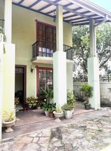a building with potted plants in front of it at Airport home stay in Ekala