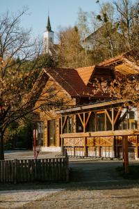 a large wooden building with a tower on a hill at Ubytování pod Borovou in Malenovice