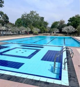 a swimming pool with blue tiles on it at Airport home stay in Ekala