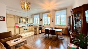 a living room with a couch and a kitchen with a table at Gael Stary Rynek 1 in Elblag