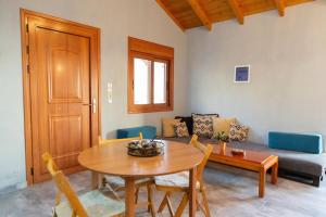 a living room with a table and a couch at Mani Tigani View Studio in Kafióna +19 photos