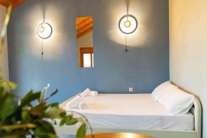 a bed in a room with two lights and a mirror at Mani Tigani View Studio in Kafióna