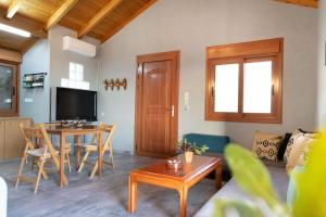 a living room with a table and a tv at Mani Tigani View Studio in Kafióna