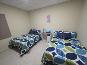a room with two beds and a table in it at Room #2 donde Alice in San Miguel