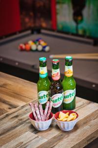 three bottles of beer and snacks on a table near a pool table at BRICKIMMERSION Suite Luxe - Cinéma Privé climatisé - Billard - Secret Room - 10min Fontainebleau - 25min Paris Ligne R in Melun +17 photos