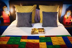 a bed with a tray of food on it at BRICKIMMERSION Suite Luxe - Cinéma Privé climatisé - Billard - Secret Room - 10min Fontainebleau - 25min Paris Ligne R in Melun