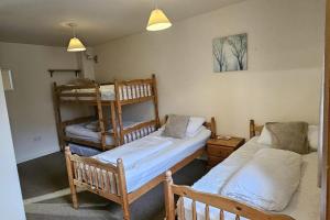 a room with two beds and a bunk bed at The Holmes Barn - Sleeps 16 - Pet friendly in Buxton