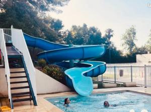 a slide in a swimming pool with two people in it at Appartement avec vue sur la mer in Six-Fours-les-Plages +31 photos