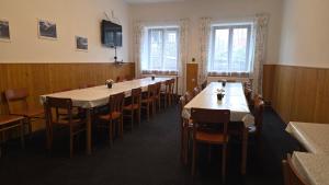 a dining room with tables and chairs and a television at Prázdninový dům Sloup - Sloup v Čechách in Sloup