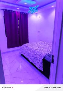 a purple room with a bed and purple curtains at Ngalle guest house in Buea