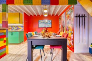 a dining room with a table and colorful walls at BRICKIMMERSION Suite Luxe - Cinéma Privé climatisé - Billard - Secret Room - 10min Fontainebleau - 25min Paris Ligne R in Melun