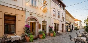 a street with tables and chairs and a building at Alma Suites Győr in Győr