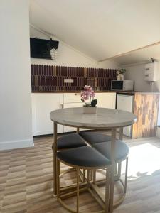 a table with a vase of flowers on it in a kitchen at Escapade Chic in Renwez