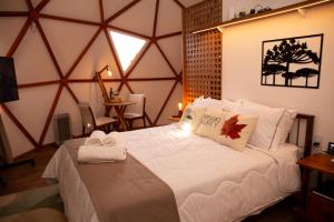 a bedroom with a large bed with towels on it at Refúgio Kuri'y Campos do Jordão in Campos do Jordão