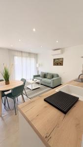 a living room with a couch and a table at Les Oliviers climatisés parking recharge électrique in Arles