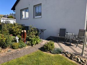 a patio with chairs and a table in front of a house at Sauerlandblick - Appartement & FeWo Wickede in Wickede (Ruhr)